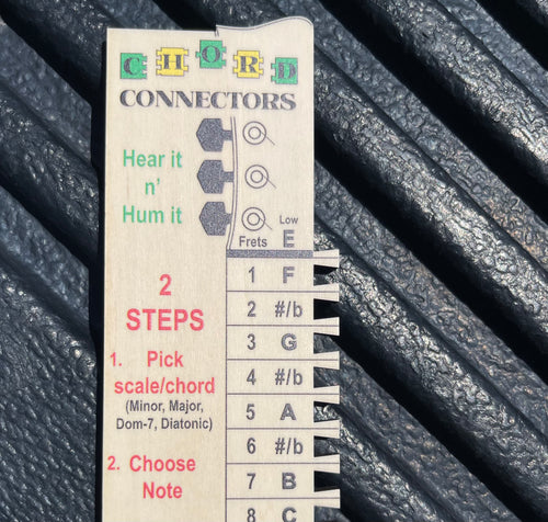 Chord Connectors Starter Stick laying on desk showing guitar note and fret number reference map